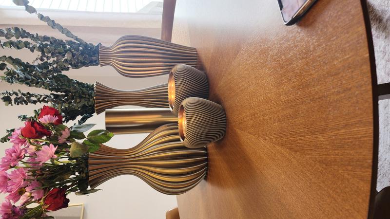Curated vase collection with flowers and candles on dining table